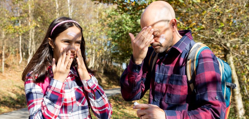 Father and Daughter Applying Sunscreen