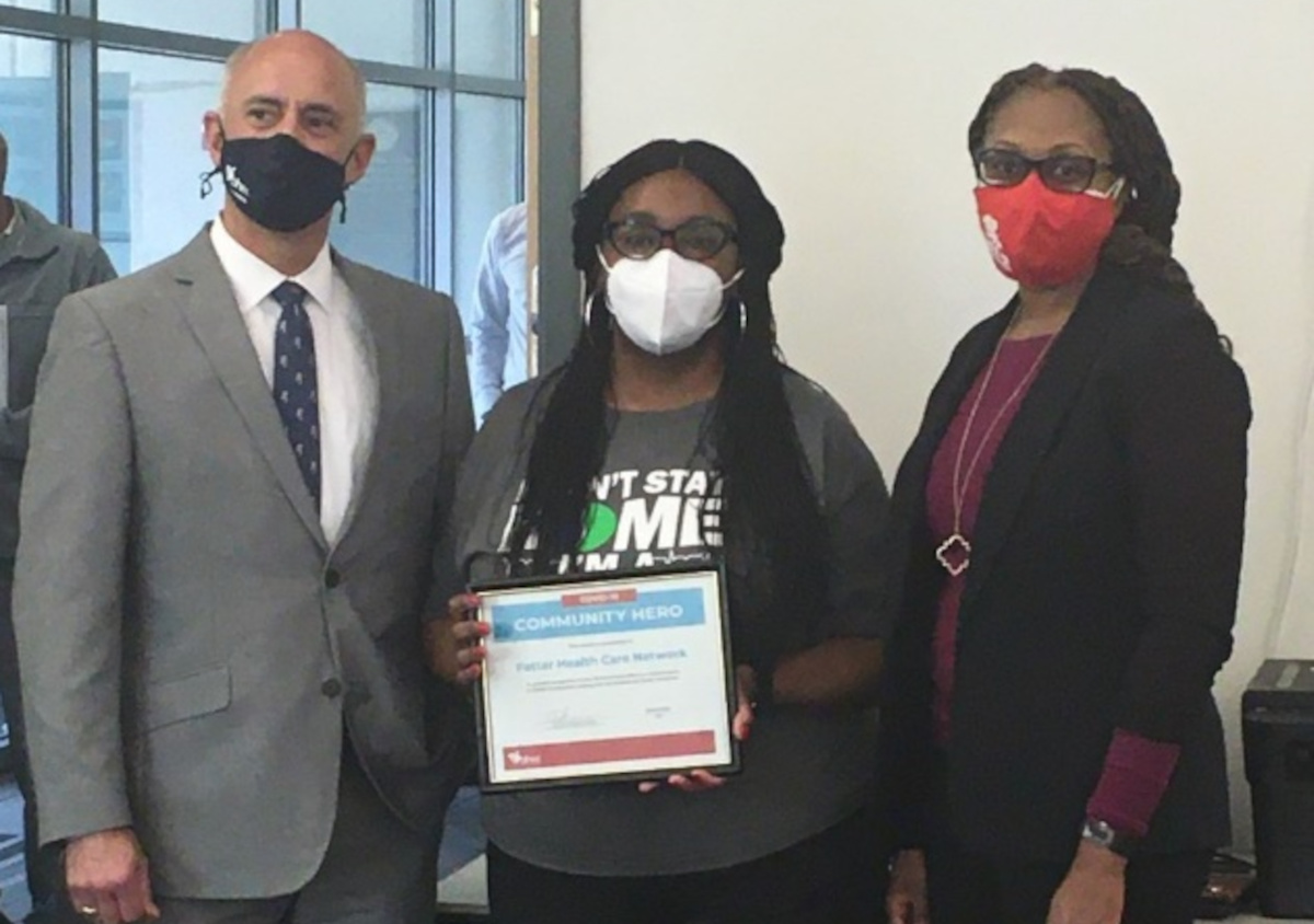 Three people standing with certificate