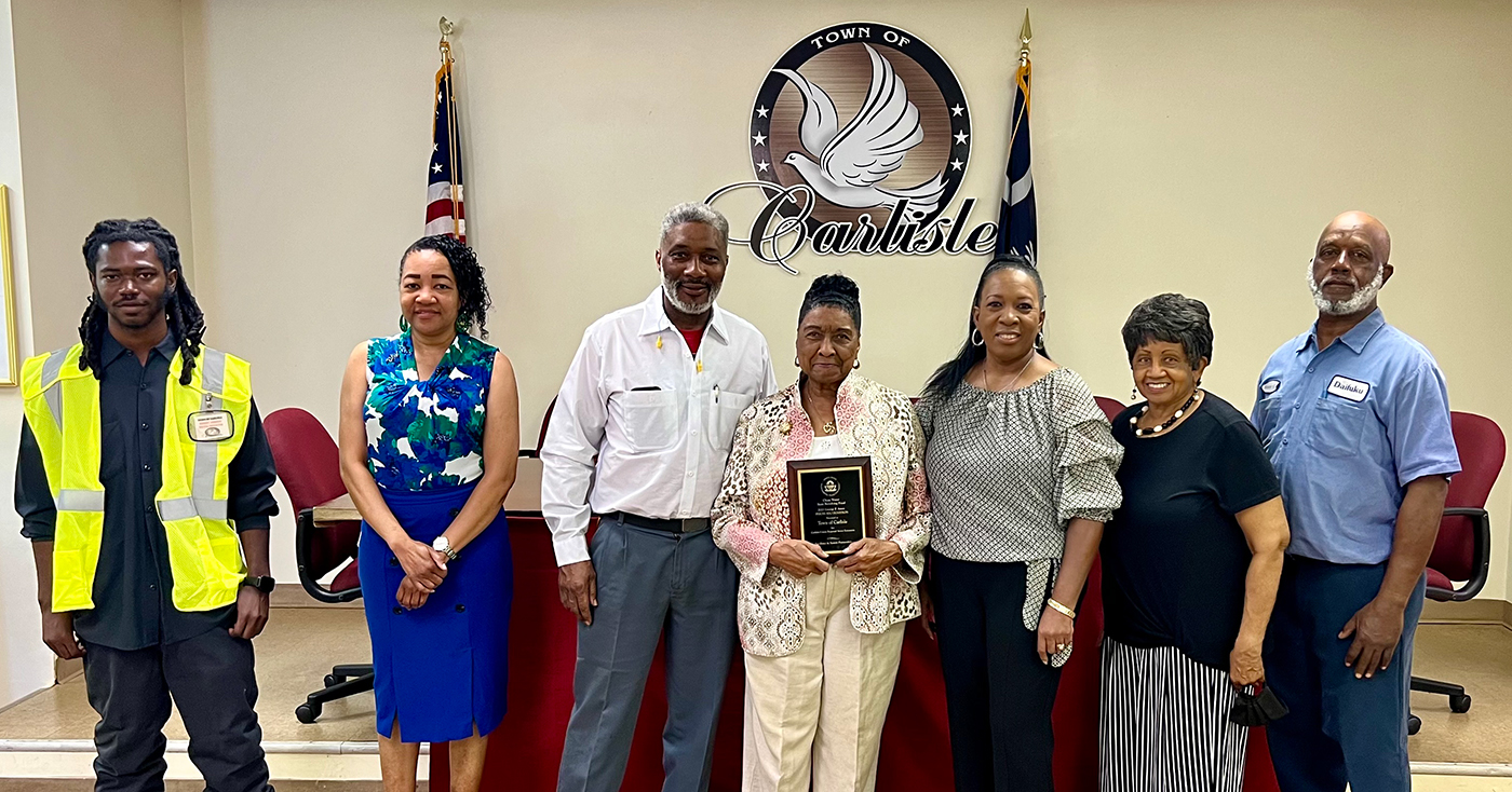 Photograph of PISCES award winners in front of the Town of Carlisle seal